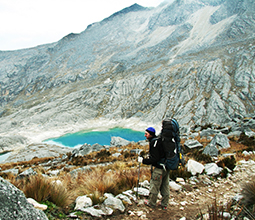 Turista apreciando la laguna en la sierra peruana